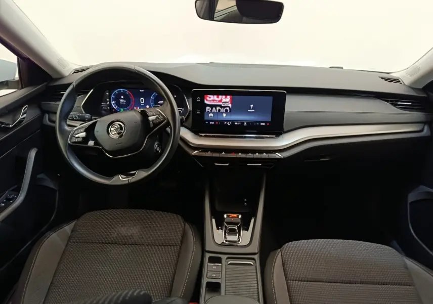 Vue intérieure frontale du tableau de bord et volant cuir alu de la Skoda Octavia 2023 avec écran tactile et combiné numérique.