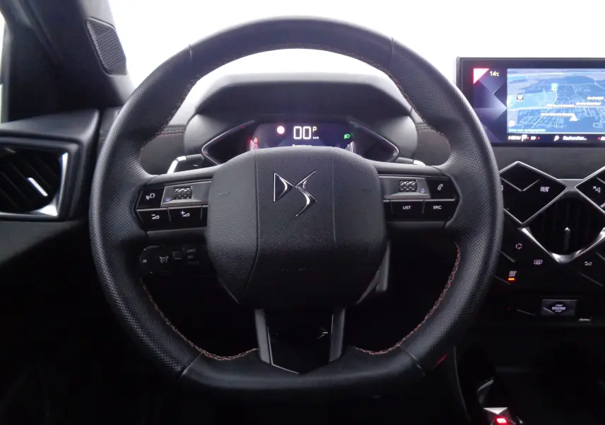Vue rapprochée du volant en cuir noir du DS3 Crossback 2021 avec tableau de bord numérique et écran tactile de navigation.