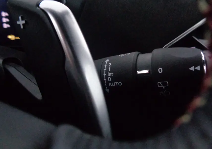 Gros plan sur la commande d'essuie-glace et la palette de changement de vitesse dans l'habitacle du DS3 Crossback blanc banquise.