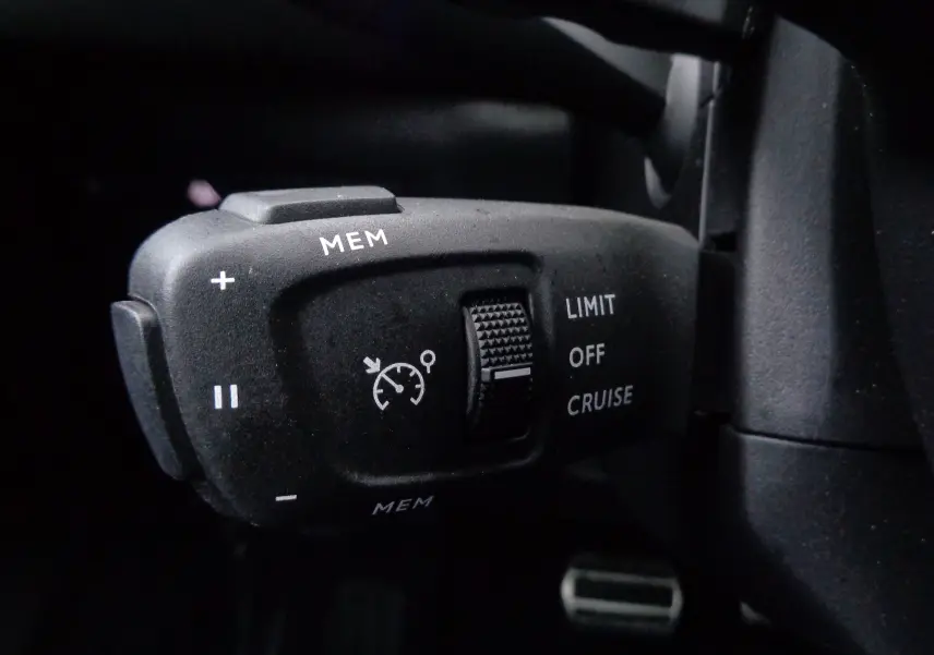 Gros plan sur la commande de régulateur de vitesse du DS3 Crossback blanc banquise, avec boutons MEM et sélecteur LIMIT/OFF/CRUISE.
