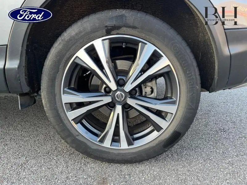 Gros plan sur la roue avant droite avec jante alliage noir et argentée du Nissan Qashqai gris Squale 2019