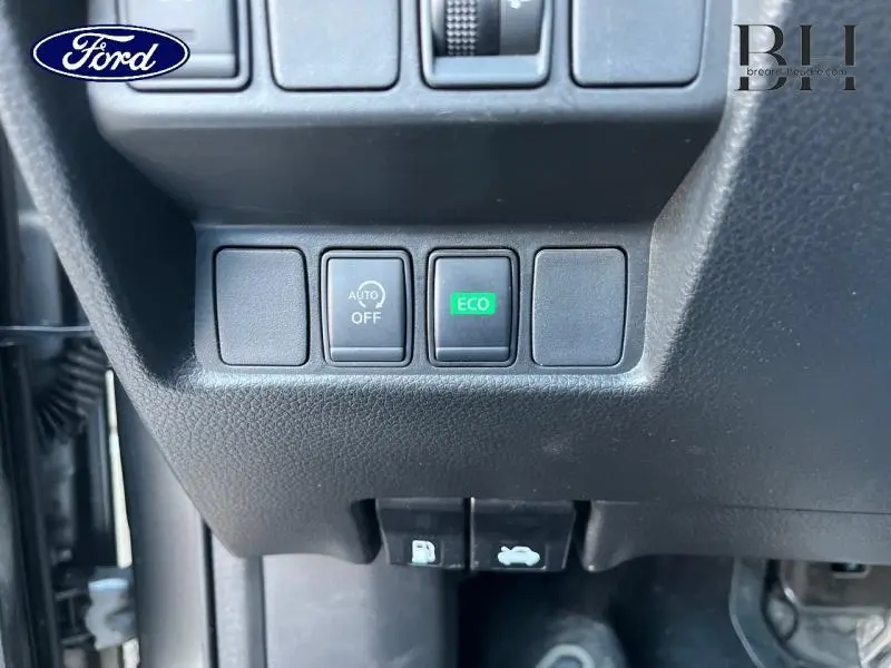 Gros plan sur les boutons de commande Eco et Auto Off du tableau de bord d'un Nissan Qashqai gris Squale 2019.