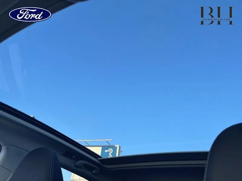 Toit ouvrant panoramique ouvert sur ciel bleu visible depuis l'intérieur avant d'un Nissan Qashqai gris Squale 2019
