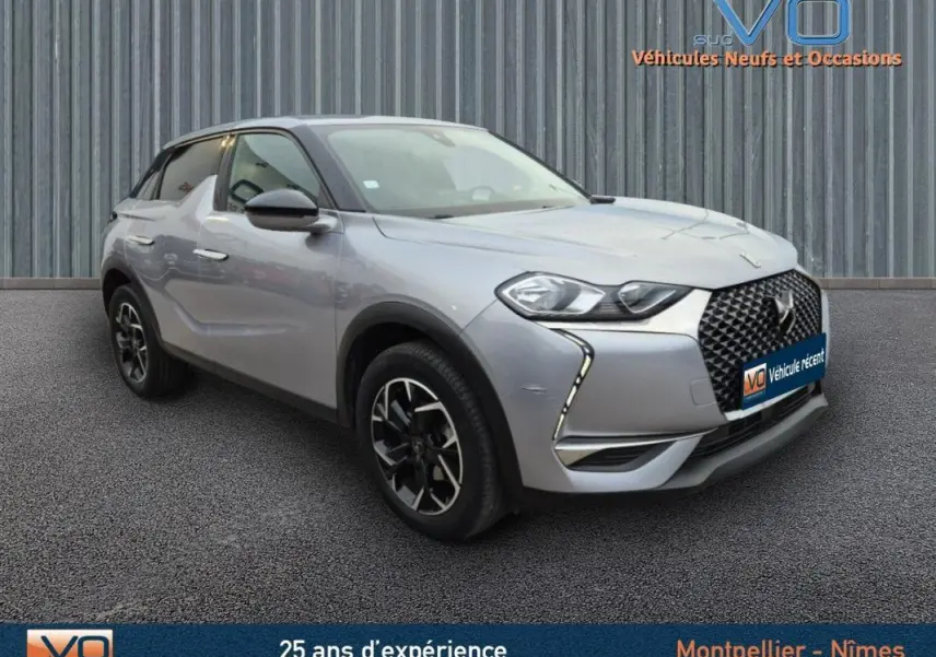 Vue 3/4 avant gauche d'un DS3 Crossback gris métallisé avec jantes alliage noires et calandre distinctive en losange.