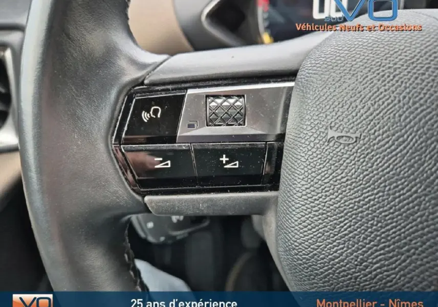Gros plan sur les commandes du volant en cuir noir du DS3 Crossback gris, mettant en valeur les boutons de volume et téléphone.