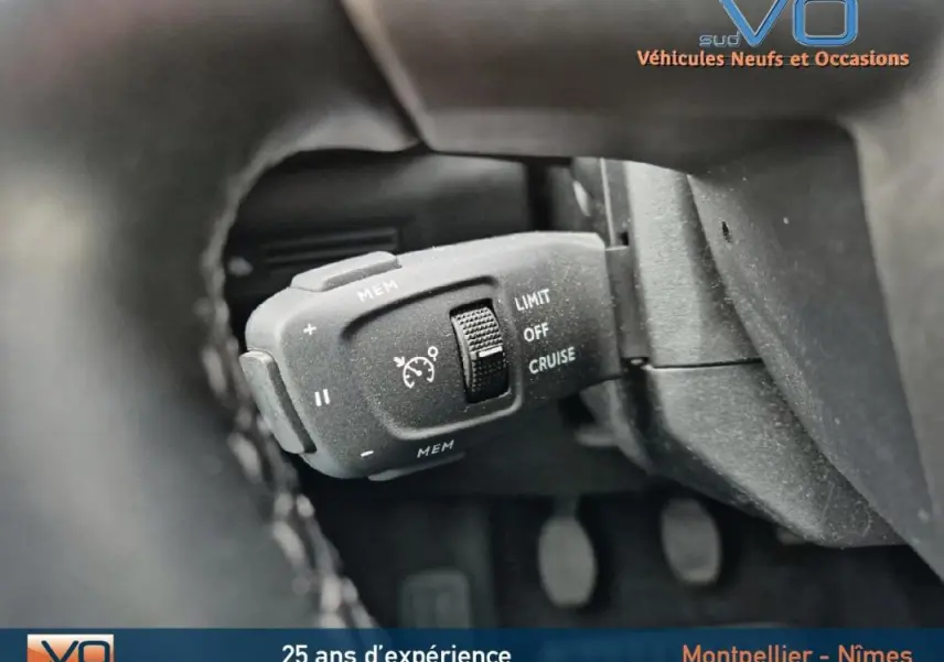 Gros plan sur la commande de régulateur de vitesse du DS3 Crossback gris, côté gauche du volant.