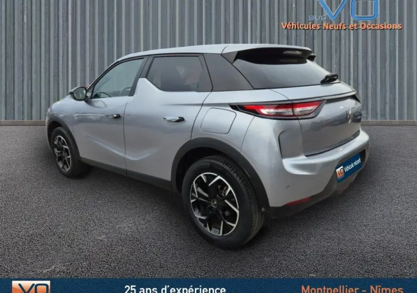 Vue 3/4 arrière droite d'un DS3 Crossback gris 2020 avec jantes alliage noires et toit noir contrasté.