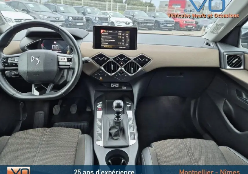 Vue intérieure avant du DS3 Crossback gris 2020, volant multifonctions, écran tactile et levier de vitesse manuel visibles.