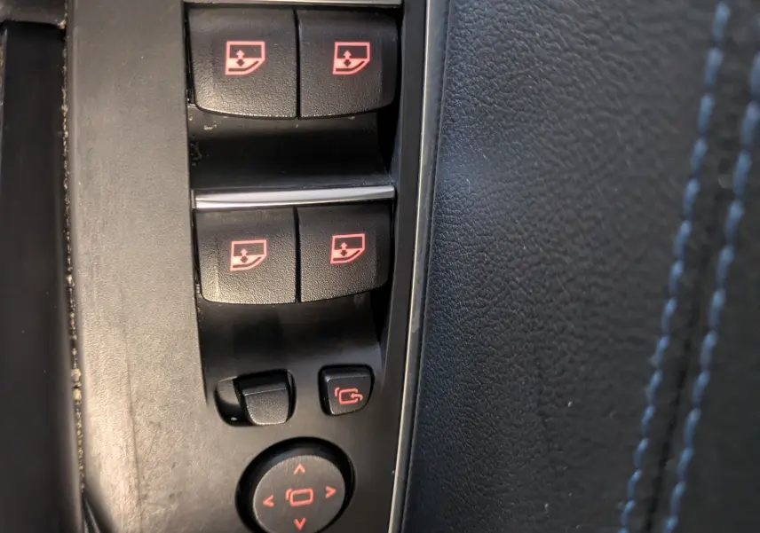 Gros plan sur les commandes de lève-vitres et rétroviseurs côté conducteur du BMW X4 blanc 2021 M SPORT.