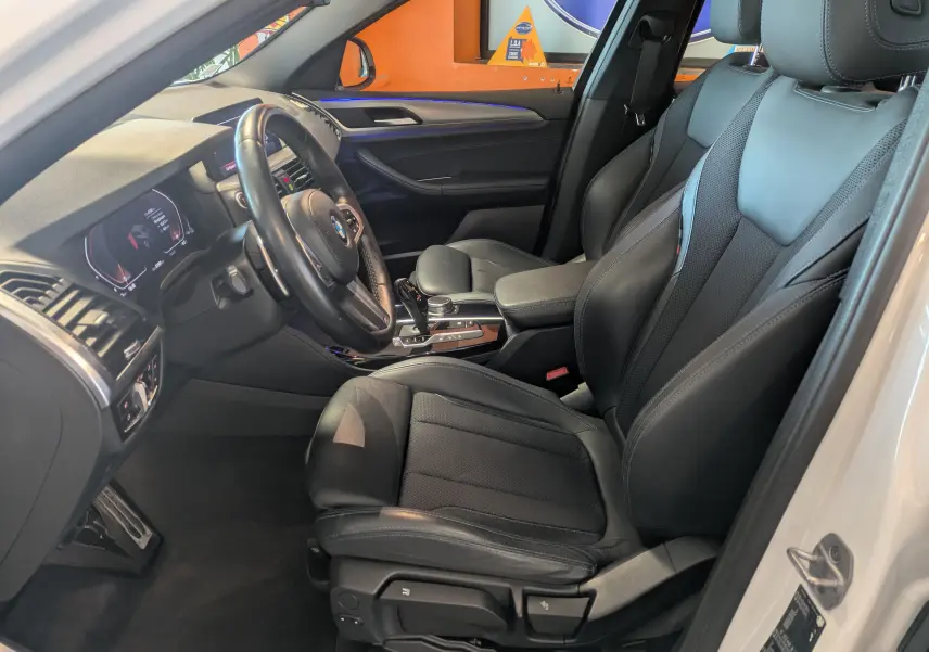 Intérieur noir cuir de la BMW X4 XDRIVE 2.0dA 190ch M SPORT 2021, vue côté conducteur avec tableau de bord et volant visibles.