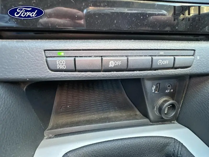 Vue rapprochée du tableau de bord avec boutons Eco Pro et contrôle de stabilité, finition noire intérieure du BMW X1 Mineralgrau.