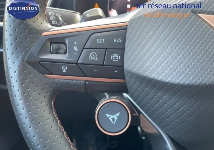 Gros plan sur le volant perforé noir avec surpiqûres marron du CUPRA Formentor 2.0 TDI 150CH DSG 2025, boutons de commande visibles.