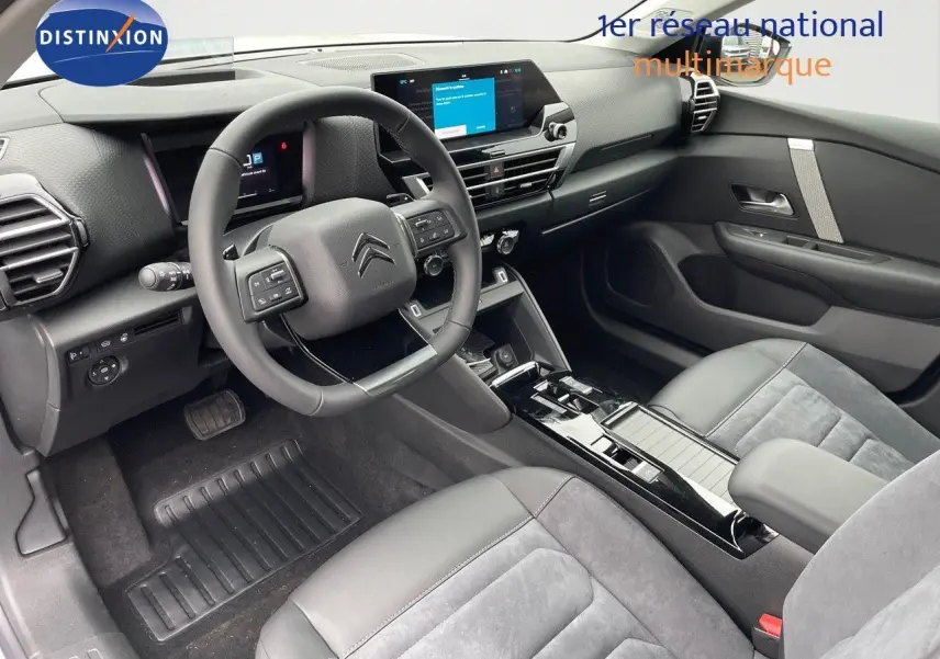 Intérieur noir et gris de la Citroën C4 2024, vue côté conducteur avec tableau de bord digital et volant multifonction.