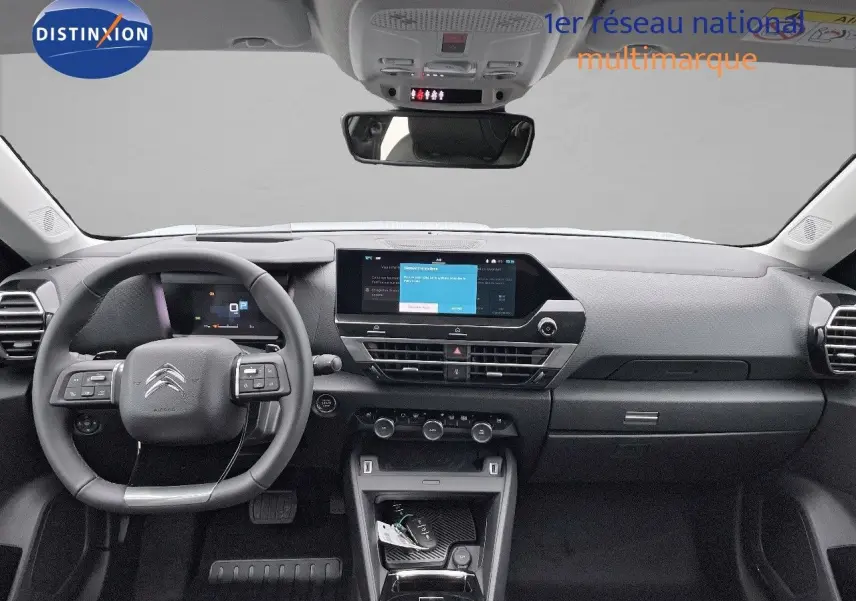 Intérieur moderne de la Citroën C4 2024, vue frontale du tableau de bord avec écran tactile et volant multifonction noir.