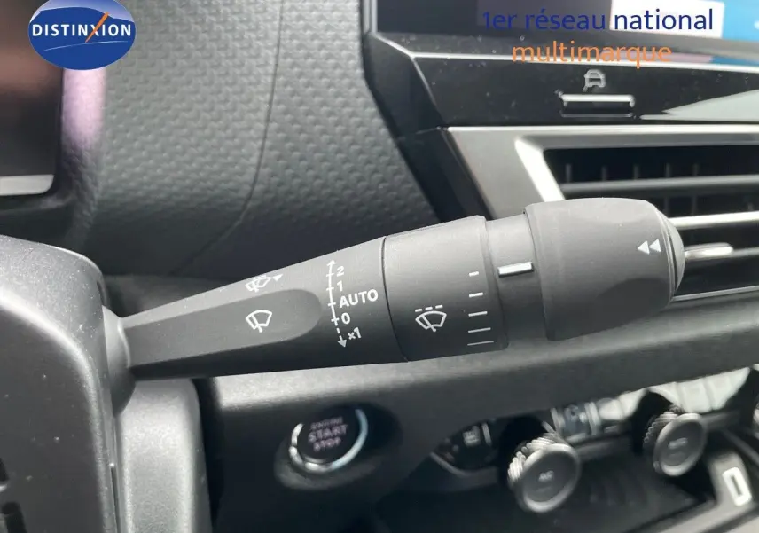 Gros plan sur la commande d'essuie-glace à gauche du tableau de bord d'une Citroën C4 blanche métal 2024.
