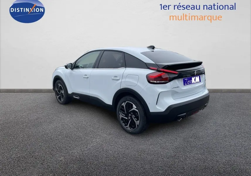 Vue 3/4 arrière droite d'une Citroën C4 blanche métal avec toit noir et jantes bicolores sur fond neutre.