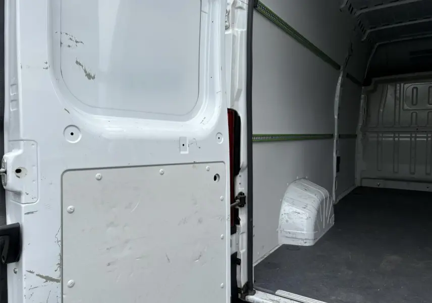 Vue intérieure arrière du fourgon blanc Opel Movano L4H3 2023 avec plancher et habillage latéraux visibles.