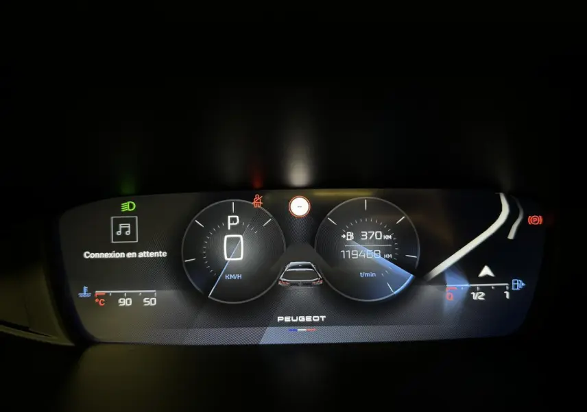 Combiné numérique du tableau de bord de Peugeot 308 SW 2022 affichant la vitesse à l'arrêt et l'autonomie restante.