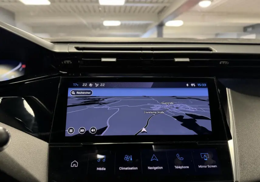 Écran tactile central de navigation allumé dans l'habitacle d'une Peugeot 308 SW gris, vue de face rapprochée.
