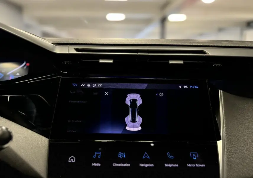 Écran tactile central du tableau de bord de la Peugeot 308 SW gris, affichant l'aide au stationnement active.