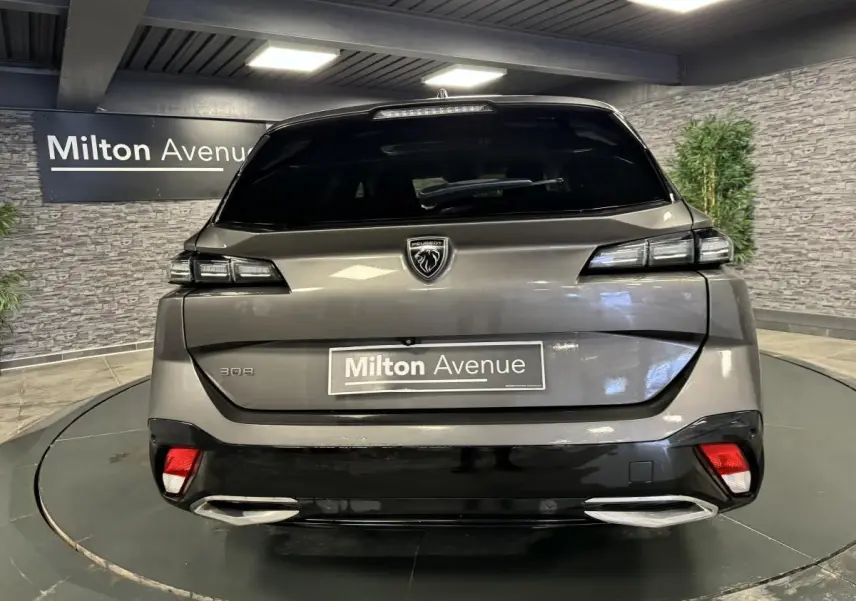 Vue arrière d'une Peugeot 308 SW gris métallisé avec feux LED et double sortie d'échappement chromée.