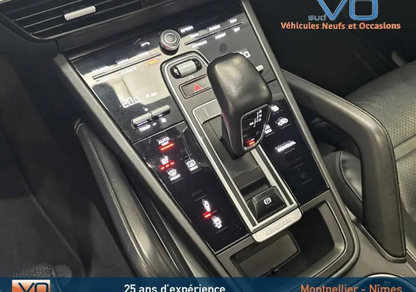 Gros plan sur la console centrale noire du Porsche Cayenne E-Hybrid 2018 avec levier de vitesse et commandes tactiles éclairées.