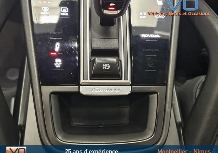 Vue rapprochée de la console centrale du Porsche Cayenne noir 2018 avec commandes tactiles et levier de boîte automatique.