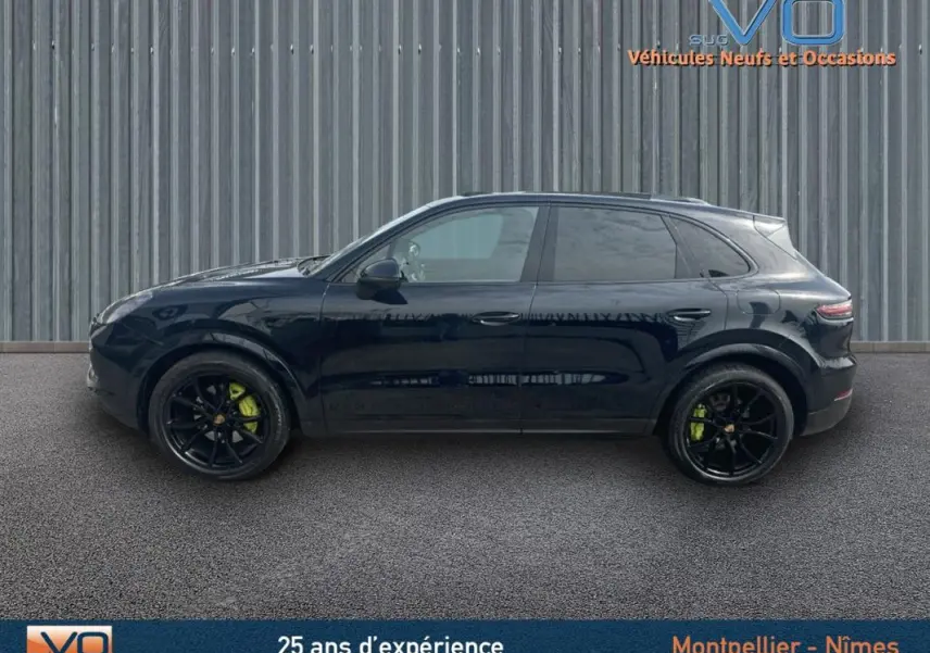 Profil latéral droit d'un Porsche Cayenne noir de 2018 avec jantes noires et étriers de frein verts visibles.