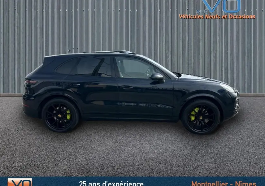 Profil latéral droit d'un Porsche Cayenne noir 2018 avec jantes noires et étriers de frein verts visibles.