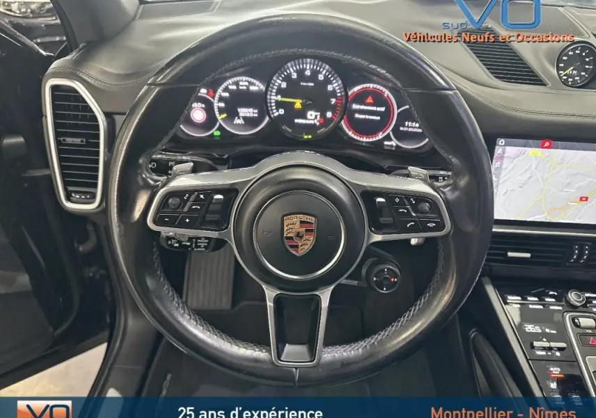 Vue rapprochée du volant sport noir et du tableau de bord numérique du Porsche Cayenne E-Hybrid 2018.