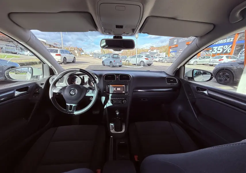 Intérieur noir de la Volkswagen Golf 1.4 TSI 2012 vu de face, avec tableau de bord et volant multifonction visibles.