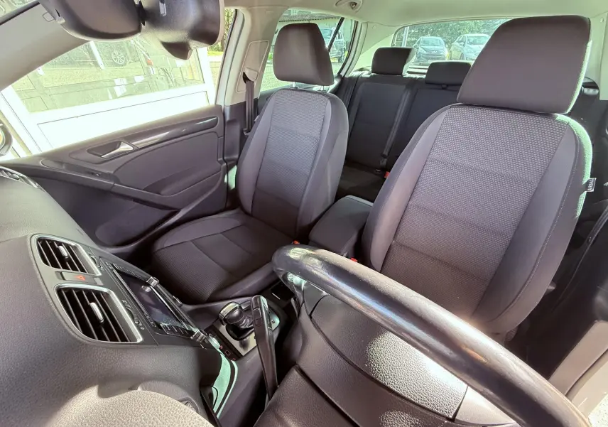 Intérieur de Volkswagen Golf 1.4 TSI 2012 vu côté conducteur, sièges tissu gris noir et tableau de bord noir.