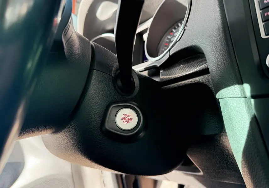 Bouton start engine stop en gros plan sur le tableau de bord noir d'une Volkswagen Golf 1.4 TSI 122 de 2012.