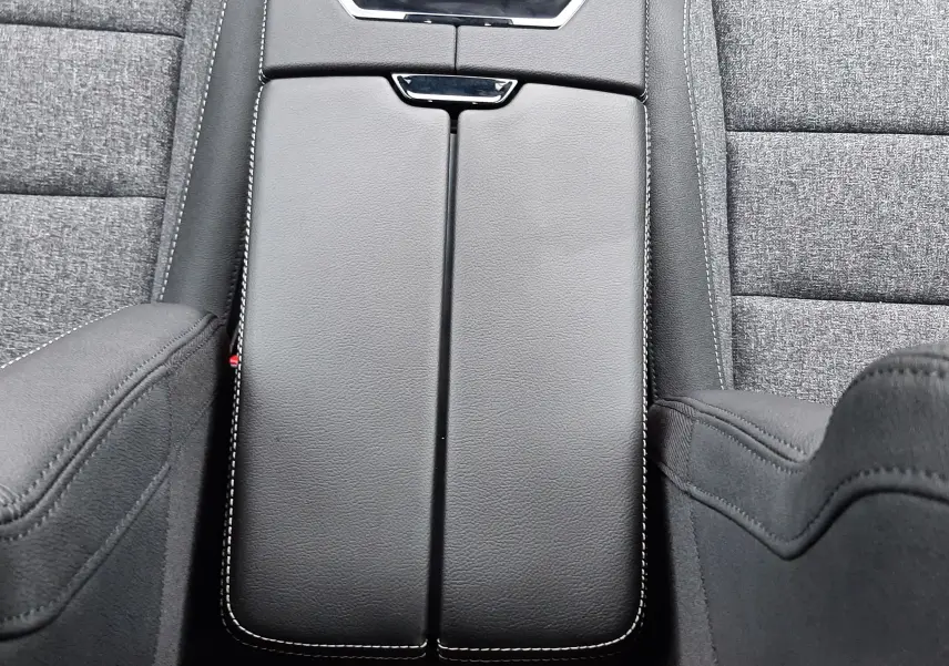 Vue plongeante sur la console centrale en cuir noir avec surpiqûres blanches du Renault Austral Ph.2 gris schiste, sièges tissu gris.