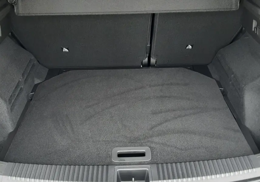 Vue intérieure du coffre spacieux et tapissé de tissu noir du Renault Austral Ph.2 gris schiste, version hybride 2025.