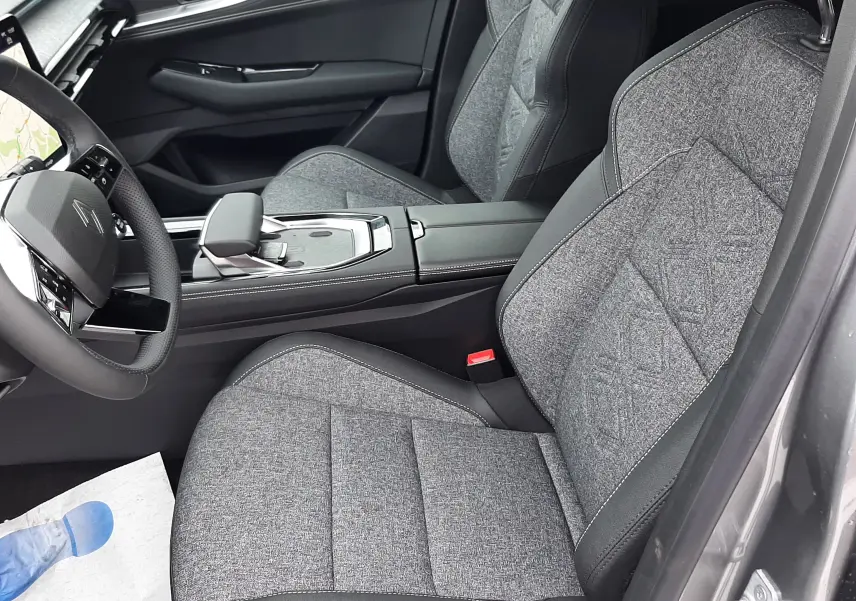 Vue intérieure côté conducteur du Renault Austral Ph.2 gris schiste, sièges tissu gris avec surpiqûres et console centrale moderne.