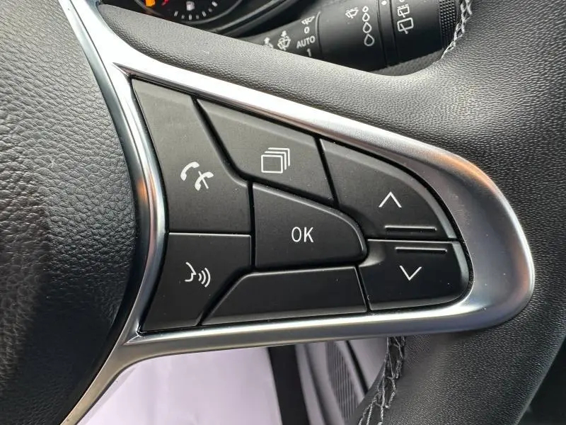 Gros plan sur les commandes multifonctions côté droit du volant d’une Renault Clio 2023, finition Gris Schiste.