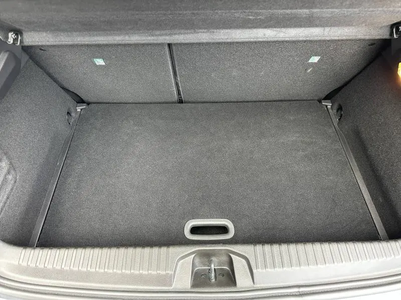 Coffre spacieux et propre vu de dessus du Renault Clio 1.0 TCe 90ch Equilibre 2023 en Gris Schiste, avec tapis de sol noir.