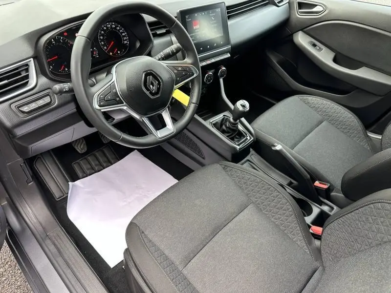 Intérieur de la Renault Clio 2023 Gris Schiste, vue côté conducteur, volant multifonction et boîte manuelle visible.