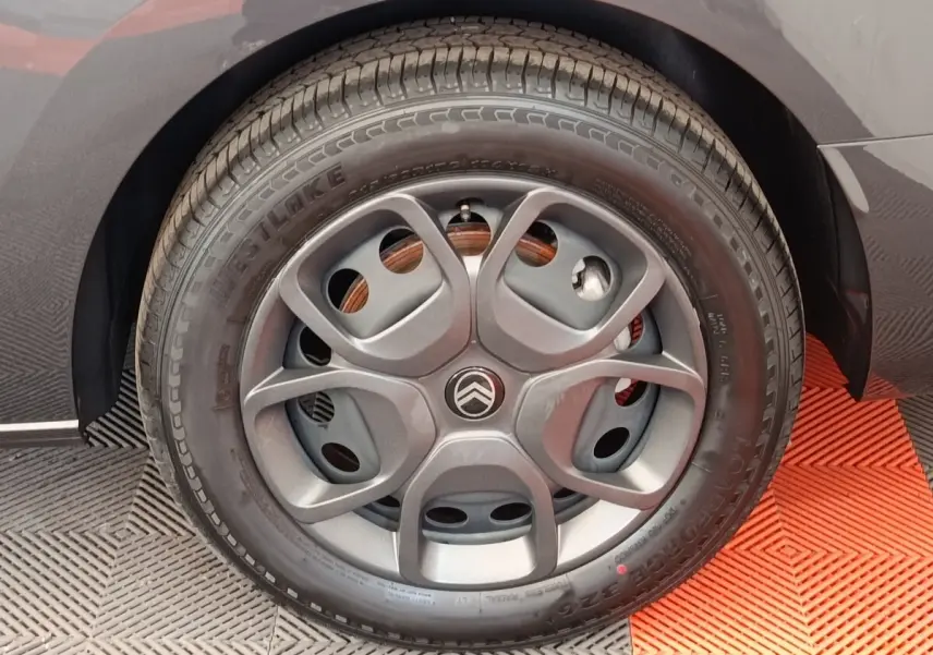 Gros plan sur la roue arrière droite d'un Citroën Jumpy gris foncé, avec partie de la carrosserie visible.
