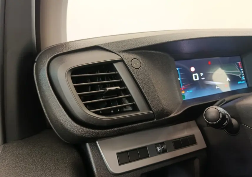 Détail intérieur côté gauche du tableau de bord gris foncé avec diffuseur d'air et écran numérique du Citroën Jumpy 2025.