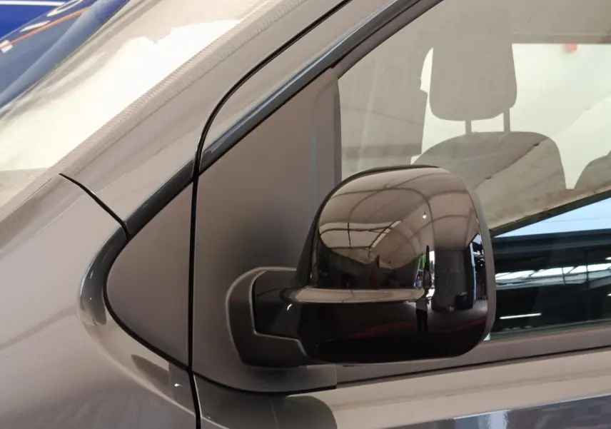 Gros plan sur le rétroviseur droit noir brillant d’un Citroën Jumpy gris foncé, vue latérale côté passager.