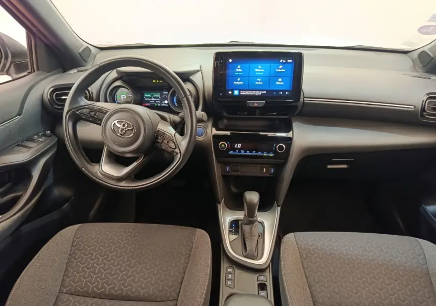 Vue intérieure avant de la Toyota Yaris Cross 1.5 Hybrid 116h Design avec tableau de bord numérique et écran tactile central.