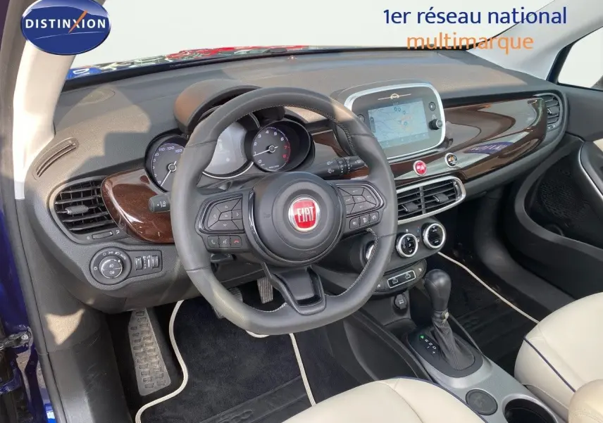 Intérieur de la Fiat 500X bleu Venezia, vue côté conducteur, tableau de bord avec écran tactile et cuir ivoire.