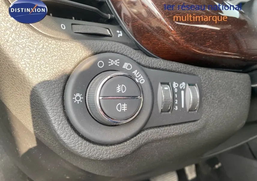 Gros plan sur la commande d'éclairage avec finition bois dans l'habitacle du Fiat 500X bleu Venezia 2021.