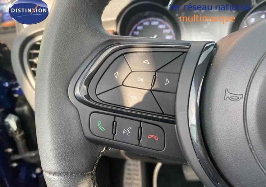Gros plan sur les commandes au volant côté gauche d'une Fiat 500X bleu Venezia 2021, avec boutons de téléphone et navigation.