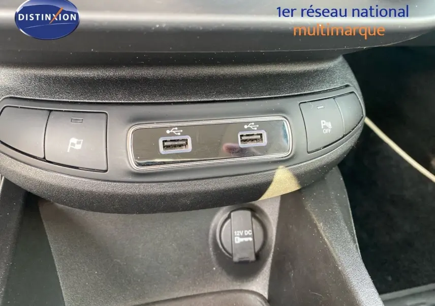 Vue rapprochée de la console centrale du Fiat 500X bleu Venezia, montrant les ports USB et commandes de stationnement.