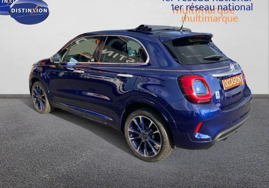 Vue 3/4 arrière gauche d'une FIAT 500X bleu Venezia métallisé avec jantes bi-ton et toit ouvrant panoramique.
