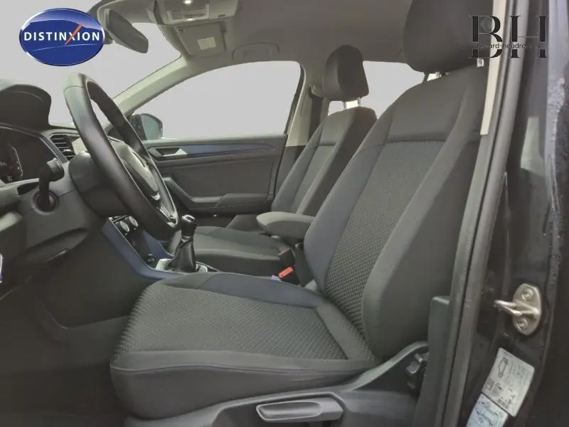 Intérieur avant du Volkswagen T-Roc 1.0 TSI gris, vue côté gauche montrant sièges tissu Cuzo et volant cuir multifonction.