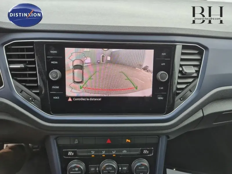 Écran tactile du tableau de bord du Volkswagen T-Roc gris montrant la caméra de recul avec lignes de guidage colorées.